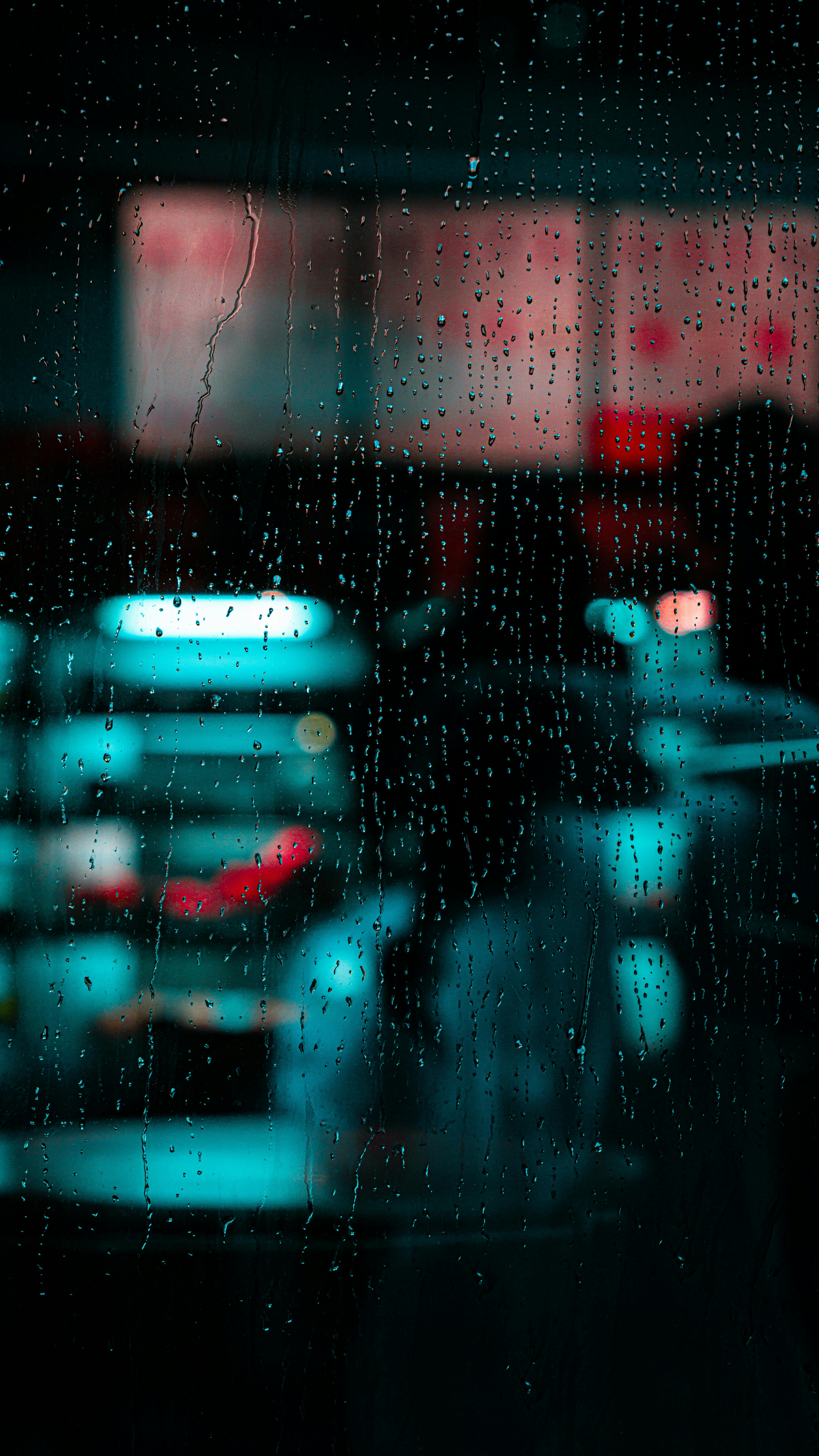 杜拜夜景中，雨滴在窗上，城市光芒模糊。