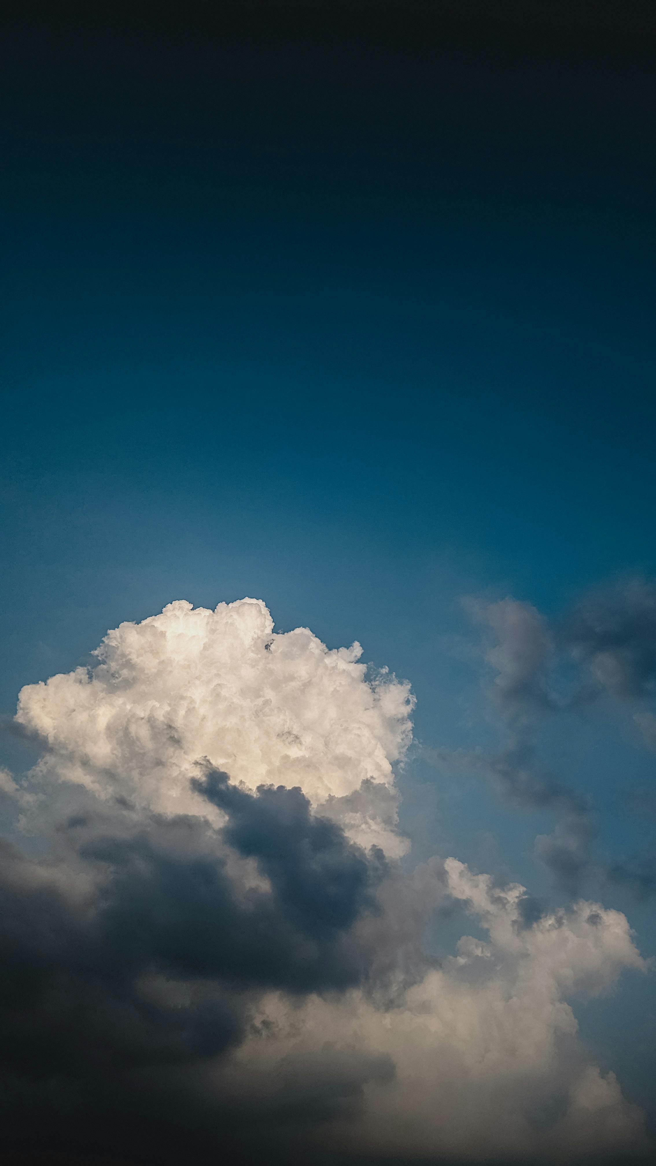 Stunning Image Of Large Clouds Against A Deep Blue Sky, Capturing A Serene And Atmospheric Cloudscape.