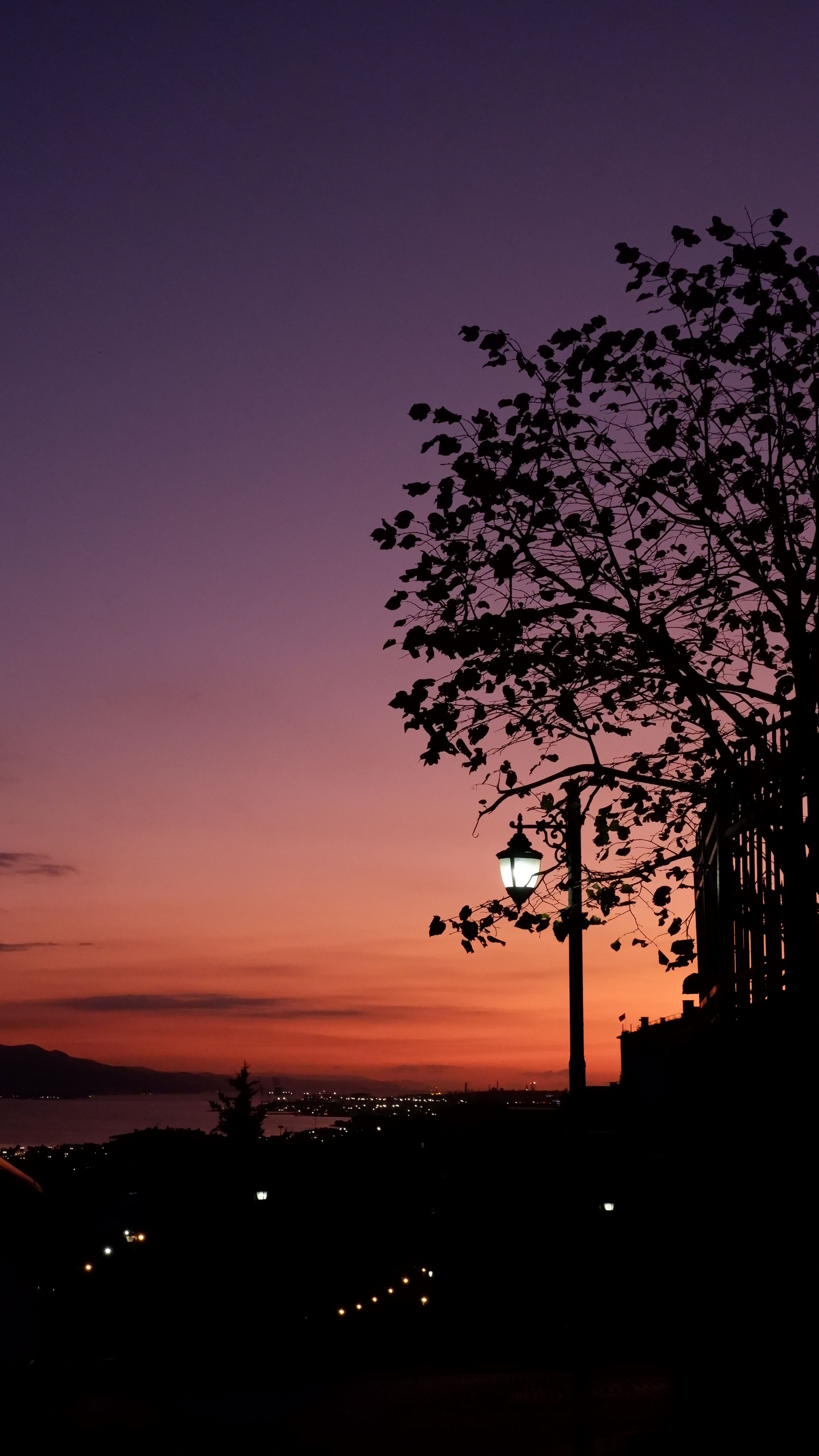A Breathtaking Sunset Painting The Sky In Vivid Hues Over A City Silhouette.