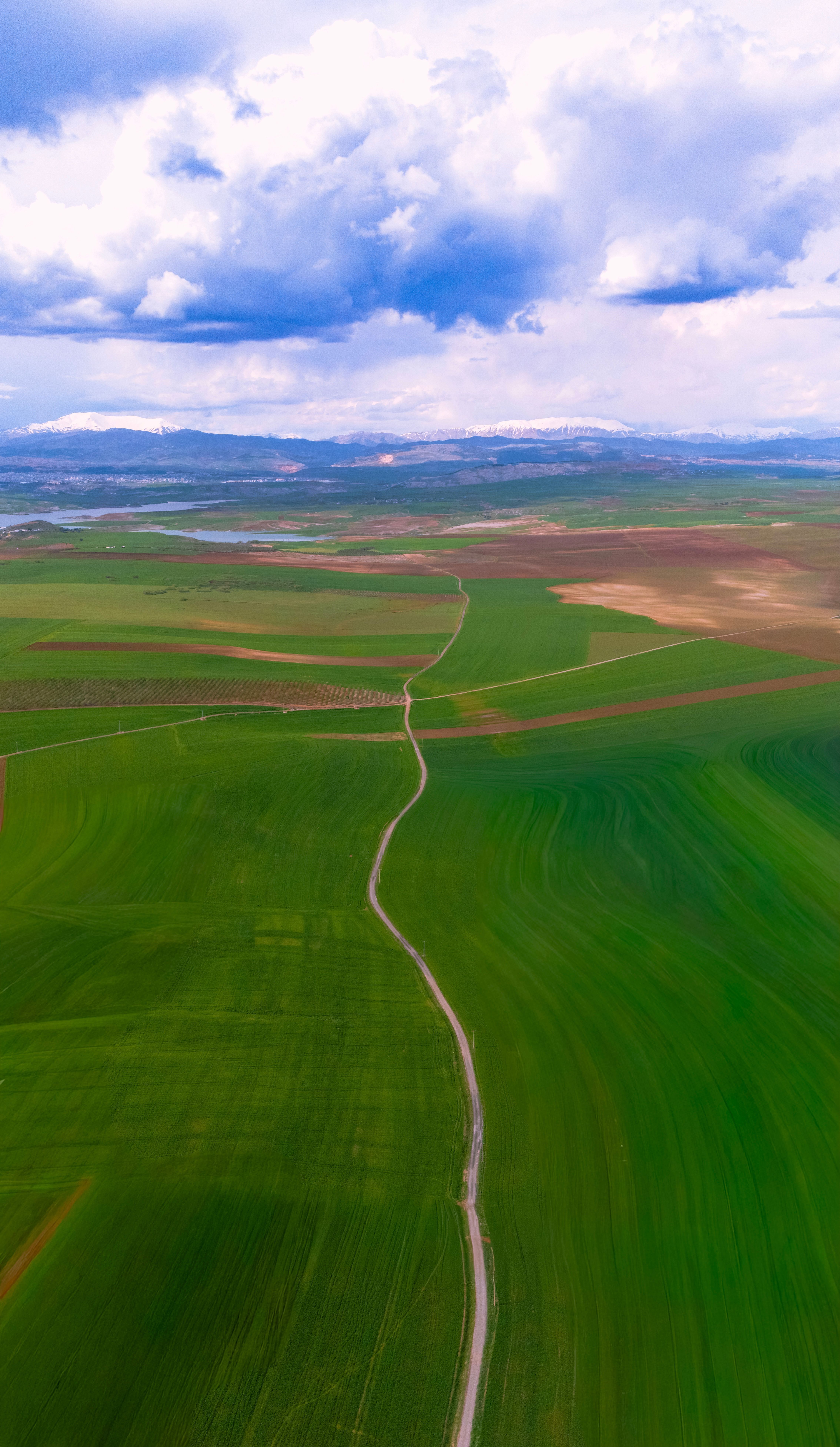 Aerial Photo Capturing Vast Green Fields Under A Cloudy Sky In Adıyaman, Türkiye.