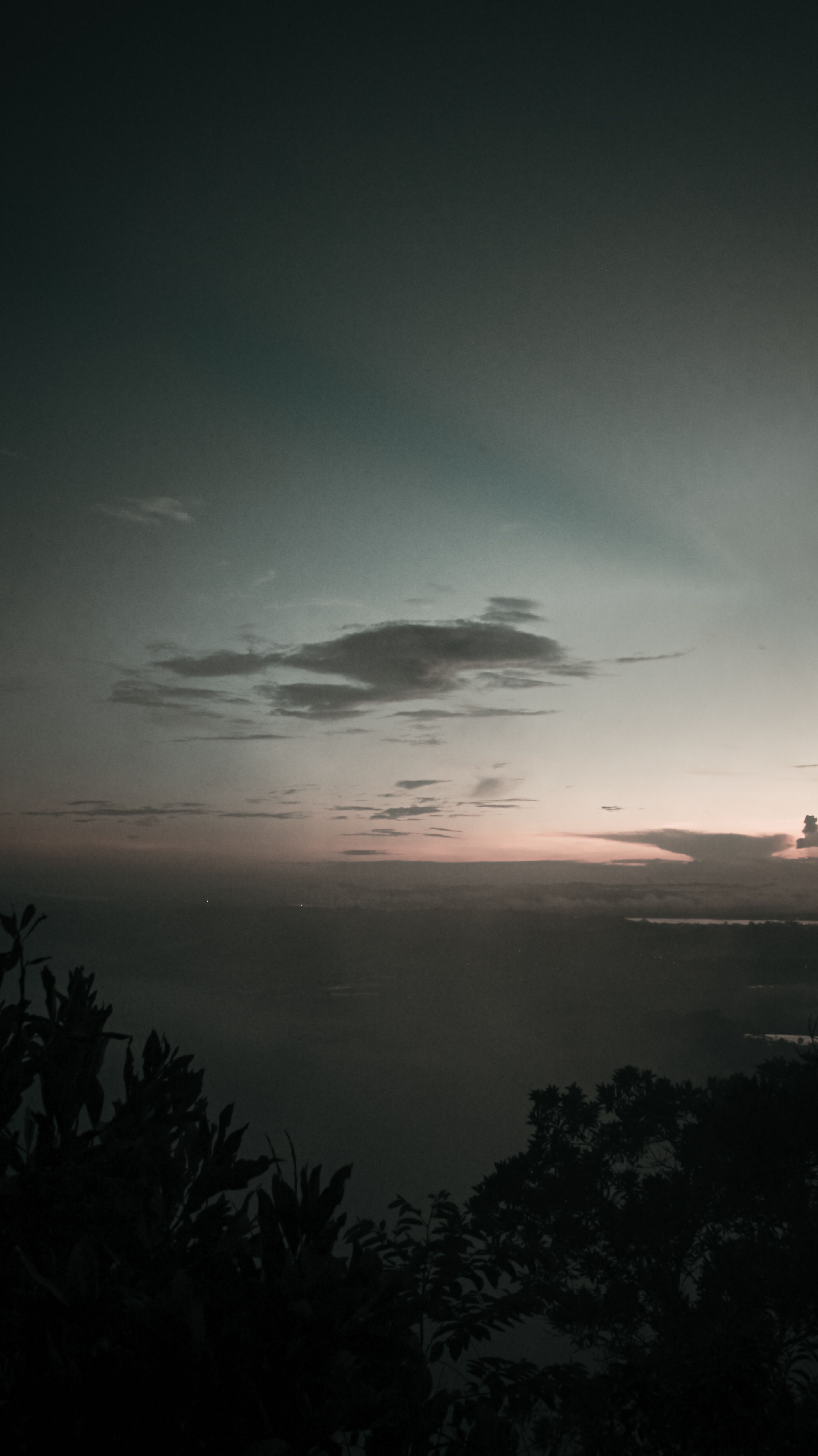 Silhouette Of Trees Growing On Mountain Slope In Peaceful Valley Against Cloudy Sundown Sky