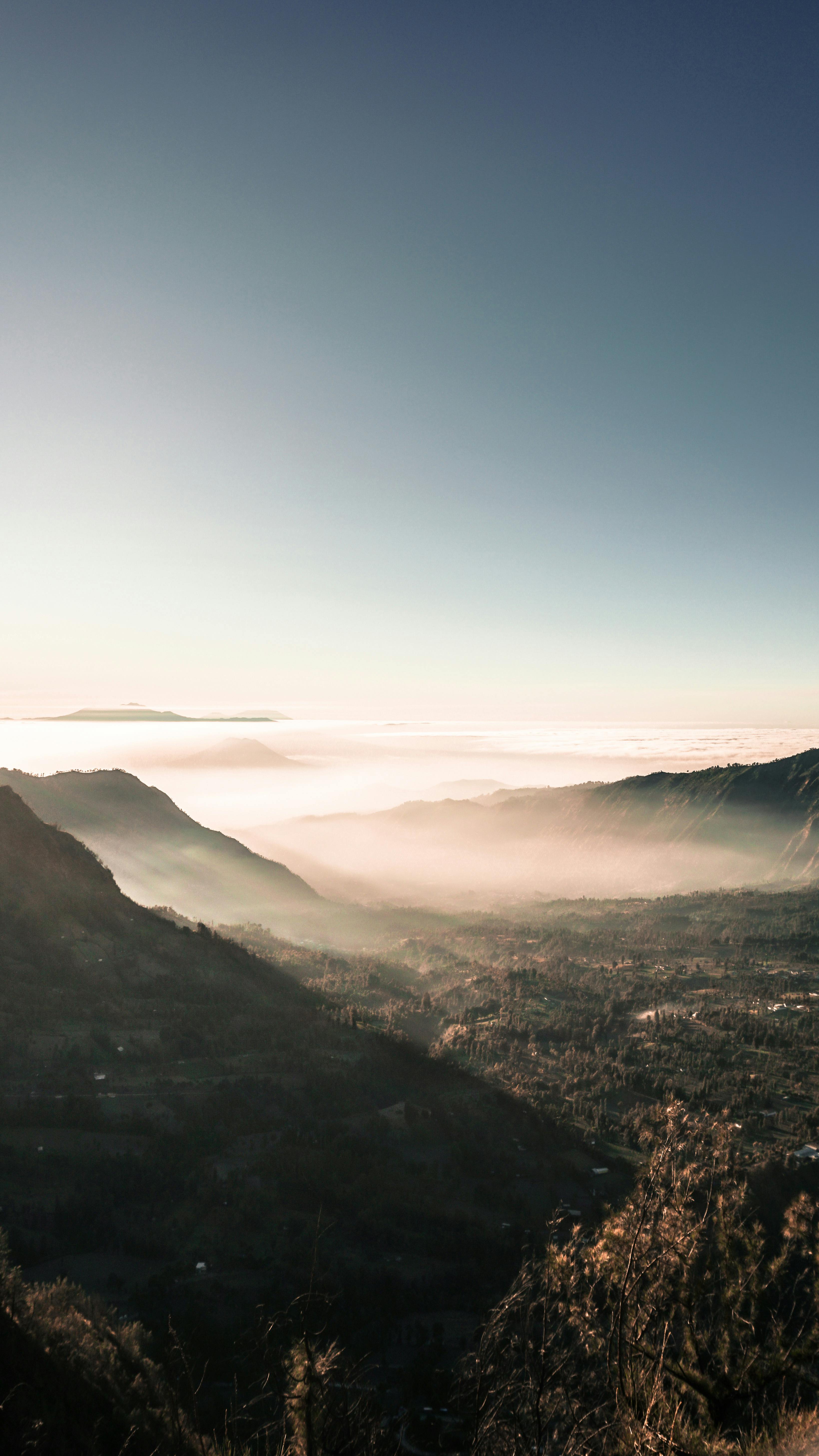 Breathtaking View Of A Mist-covered Mountain Valley At Sunrise, Capturing Nature's Serene Beauty.