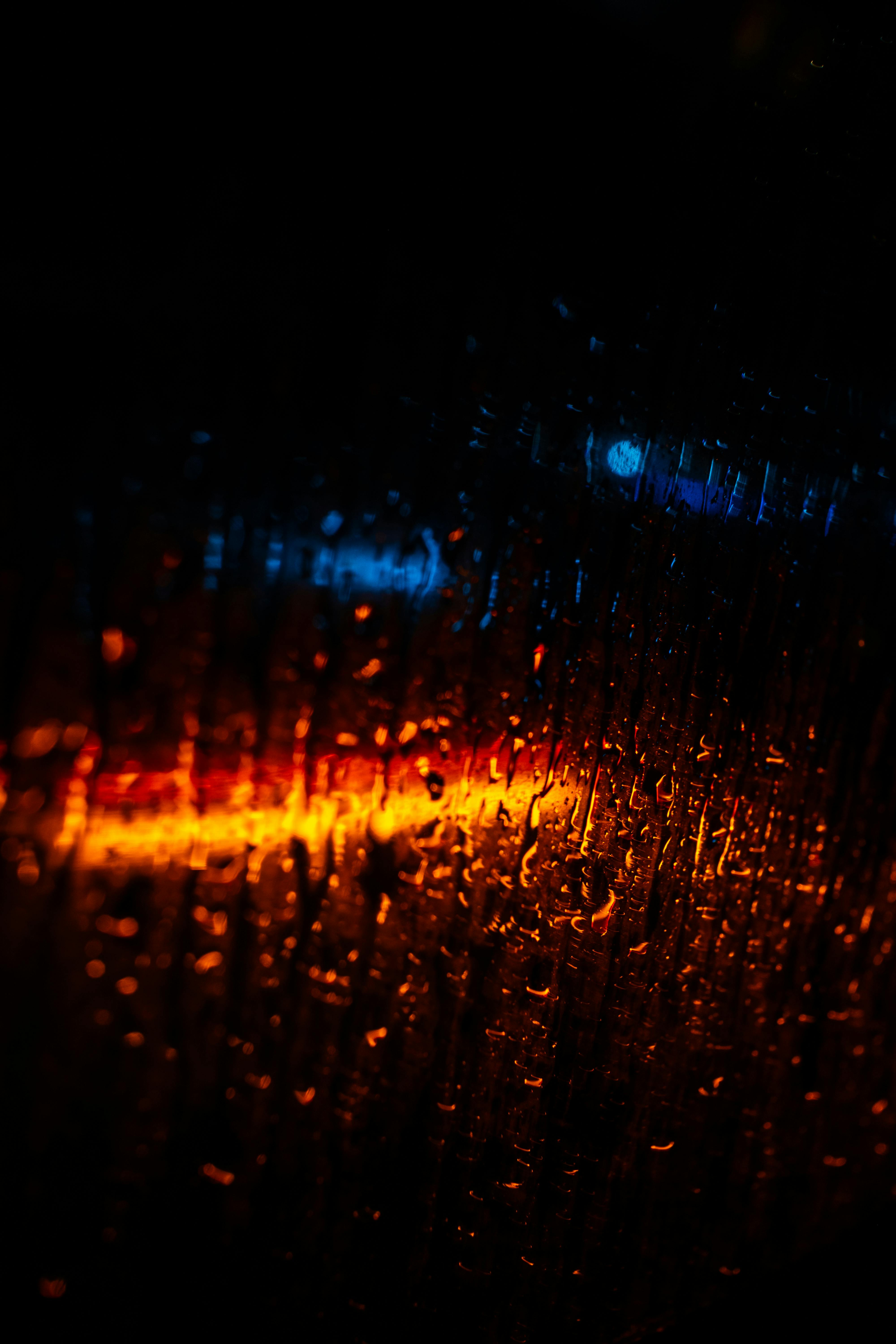 Vibrant Abstract Of Raindrops On Glass With Blue And Orange Lights.