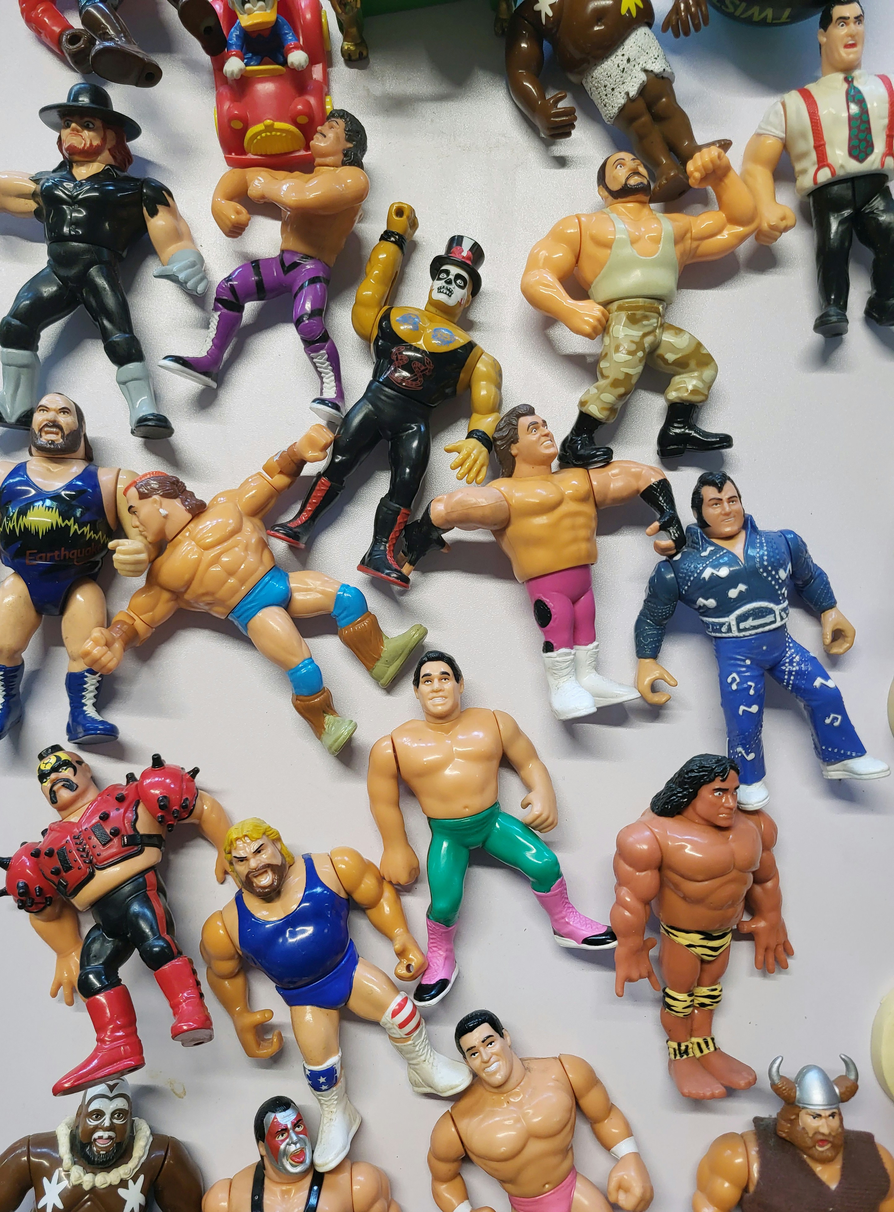 Many Colorful Wrestling Action Figures Scattered Across A Surface.