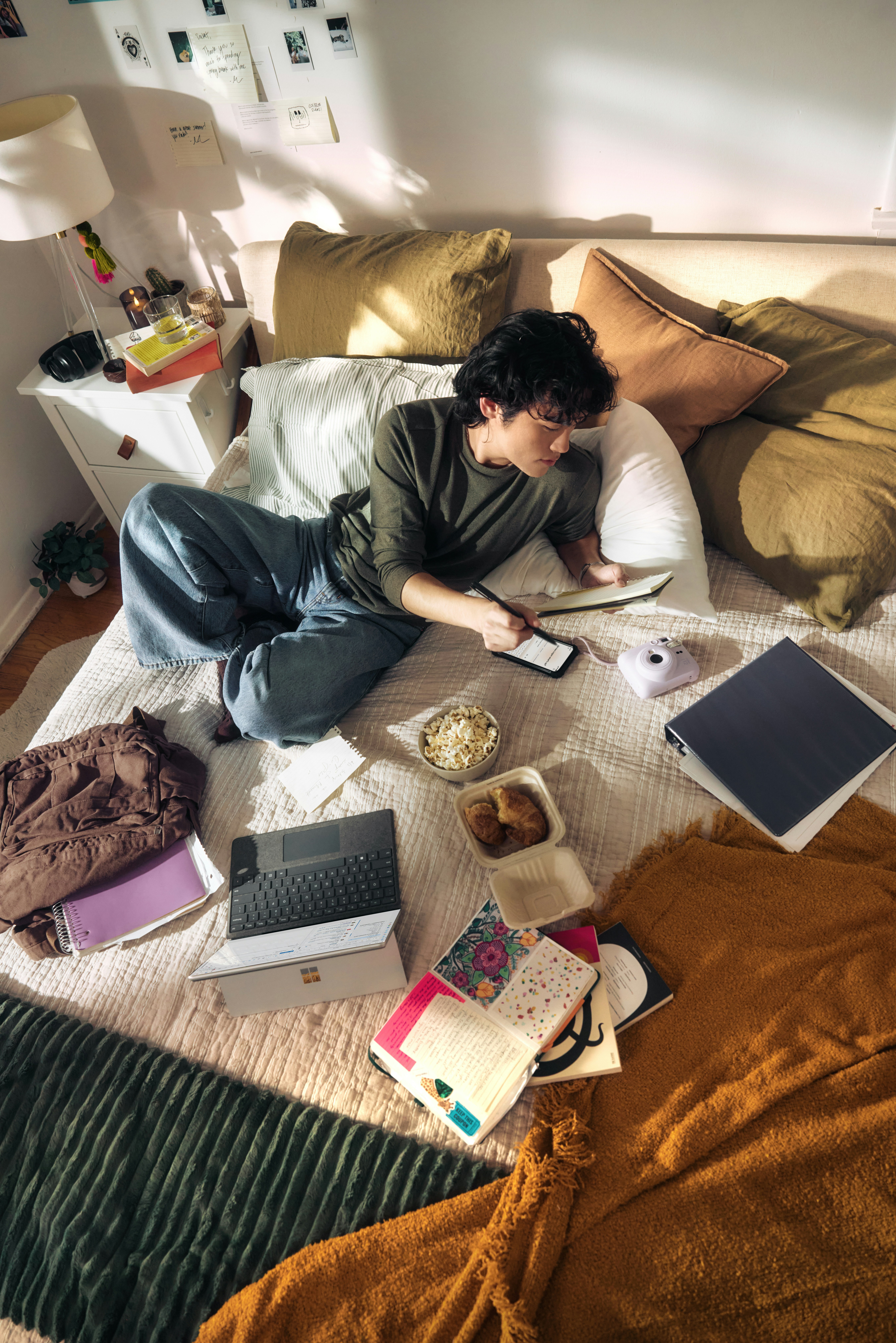 Young Man On Bed With Laptop And Snacks