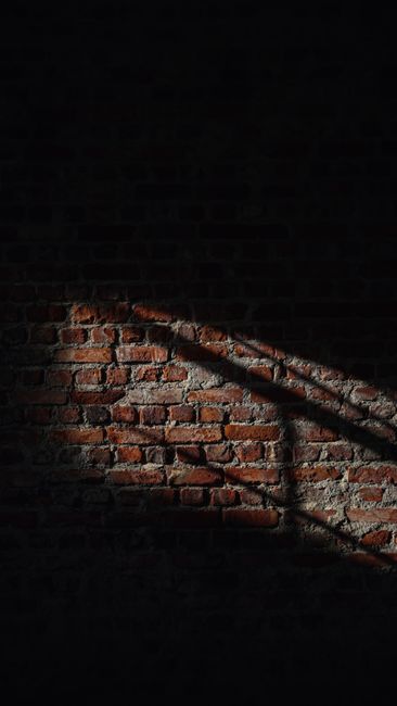 A Brick Wall Captured With Striking Sunlight And Shadows Creating A Dramatic Contrast. wallpaper preview
