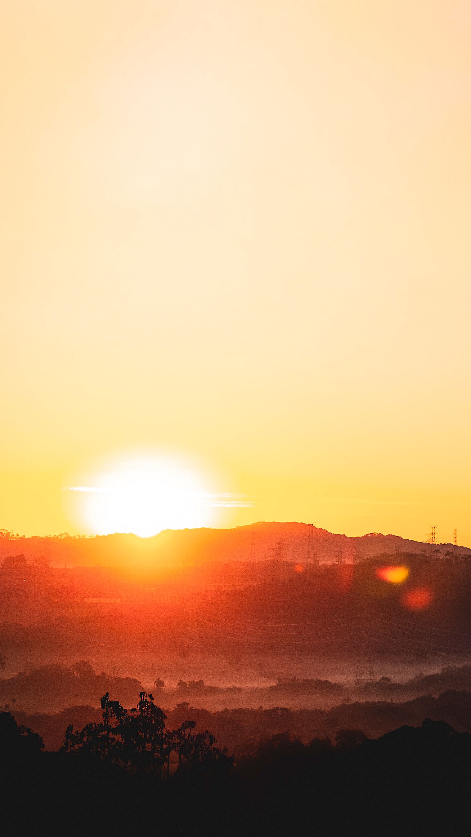 Captivating Sunrise Casting Warm Glow Over Misty Hills And Clear Sky. HD mobile wallpaper
