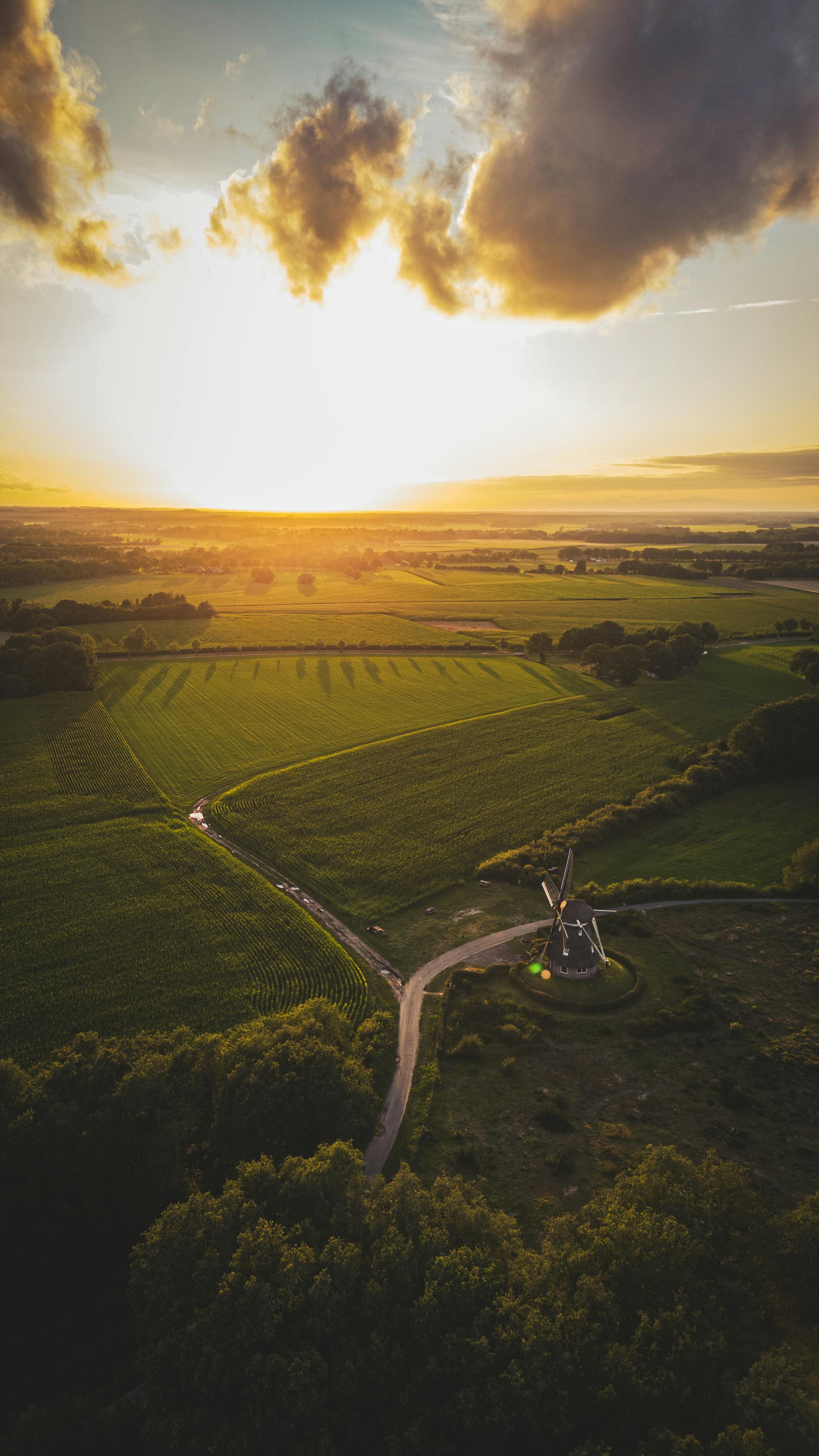 Scenic Aerial View Of A Windmill Amidst Lush Fields At Sunset In Ruinen, Netherlands. HD mobile wallpaper