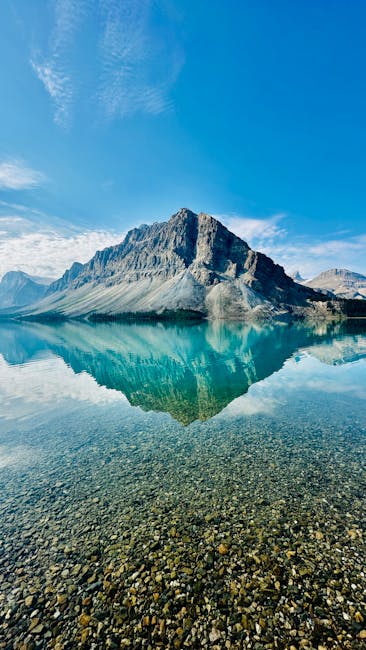 Majestic Mountain Reflected In Clear Blue Lake Under A Bright Sky, Offering A Serene Nature View. wallpaper preview