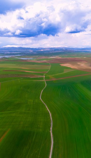 Aerial Photo Capturing Vast Green Fields Under A Cloudy Sky In Adıyaman, Türkiye. wallpaper preview