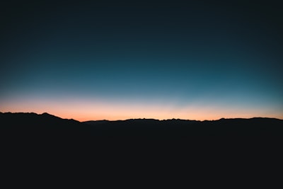 Dark Mountain Silhouettes Against A Colorful Twilight Sky.