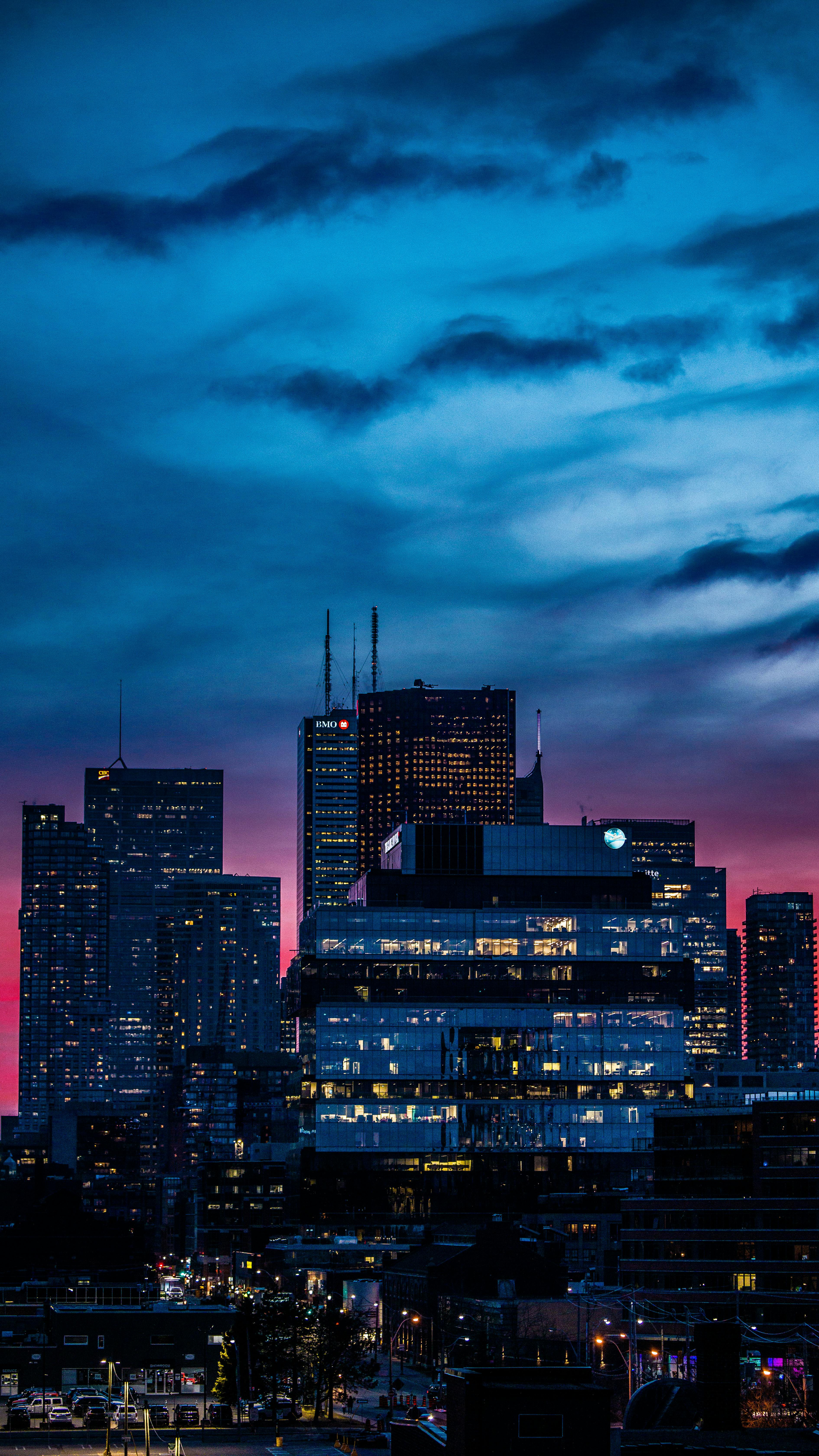 A Vibrant City Skyline With A Dramatic Twilight Sky And Illuminated Buildings. HD mobile wallpaper