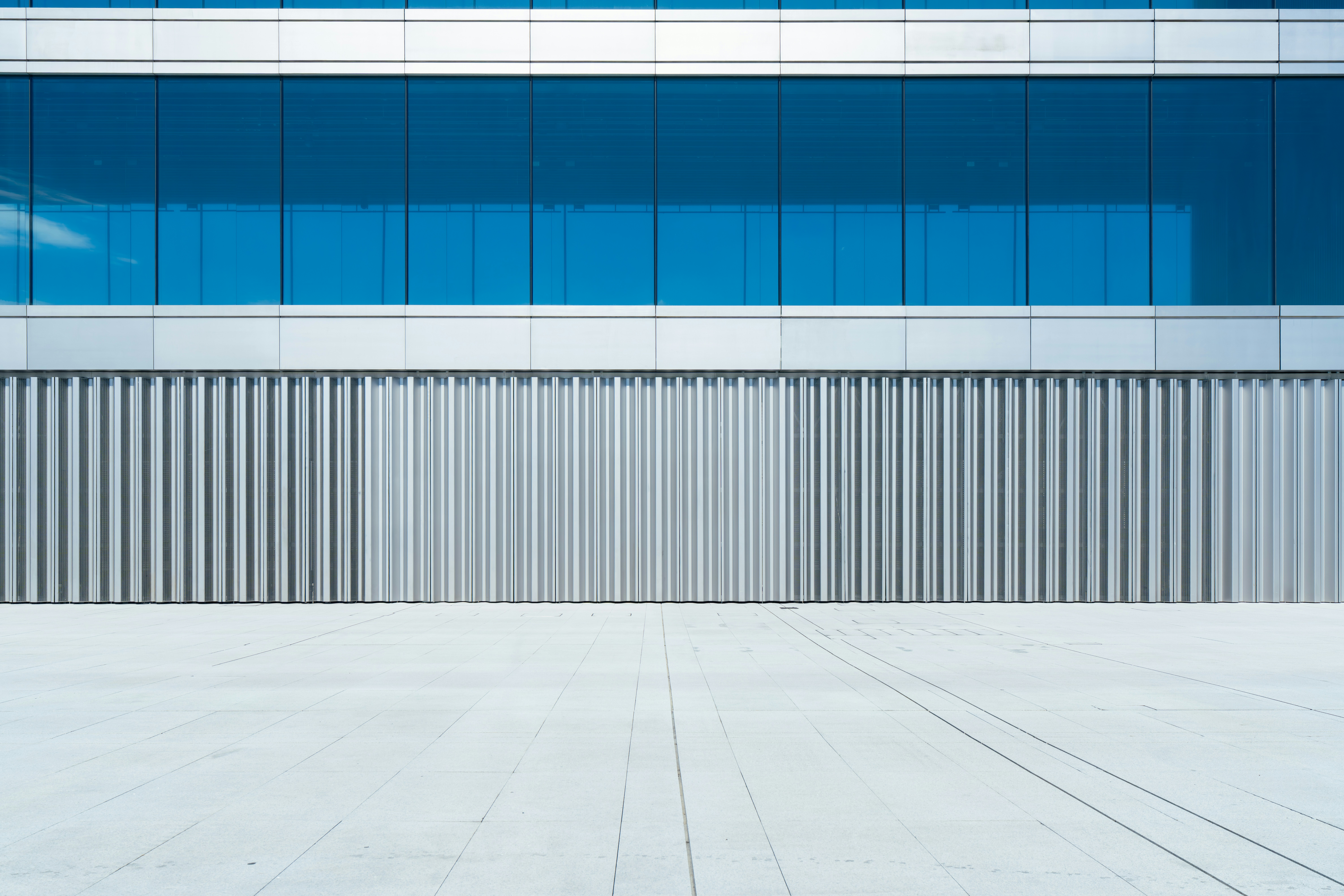 Modern Building Facade With Blue Windows And Grey Textured Wall. HD mobile wallpaper