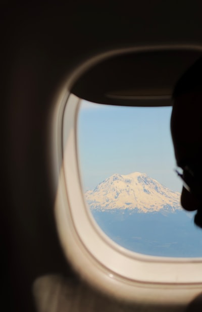 Passenger Views Snow-capped Mountain From Airplane Window. wallpaper preview