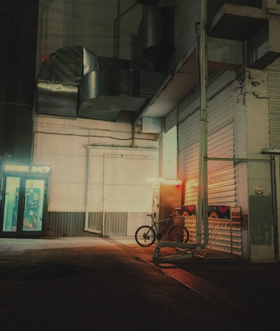 A Bicycle Parked Outside A Building At Night wallpaper preview