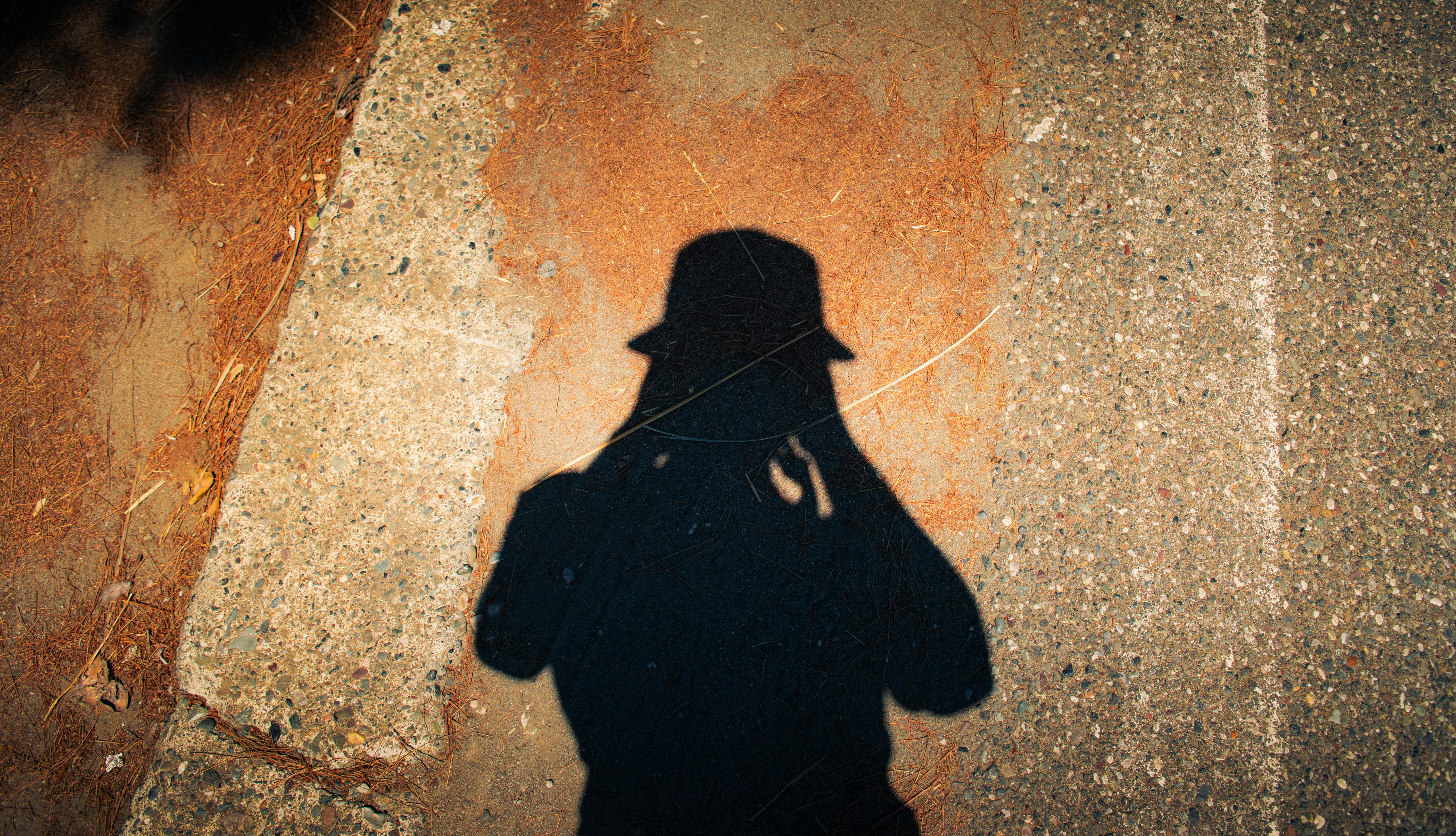 Shadow Of A Person In A Hat On Textured Ground. HD mobile wallpaper