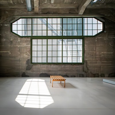 Minimalist Interior Of The Fenix Museum In Rotterdam, Featuring Industrial Architecture, Large Windows, And A Single Wooden Bench Illuminated By Soft Natural Light. wallpaper preview