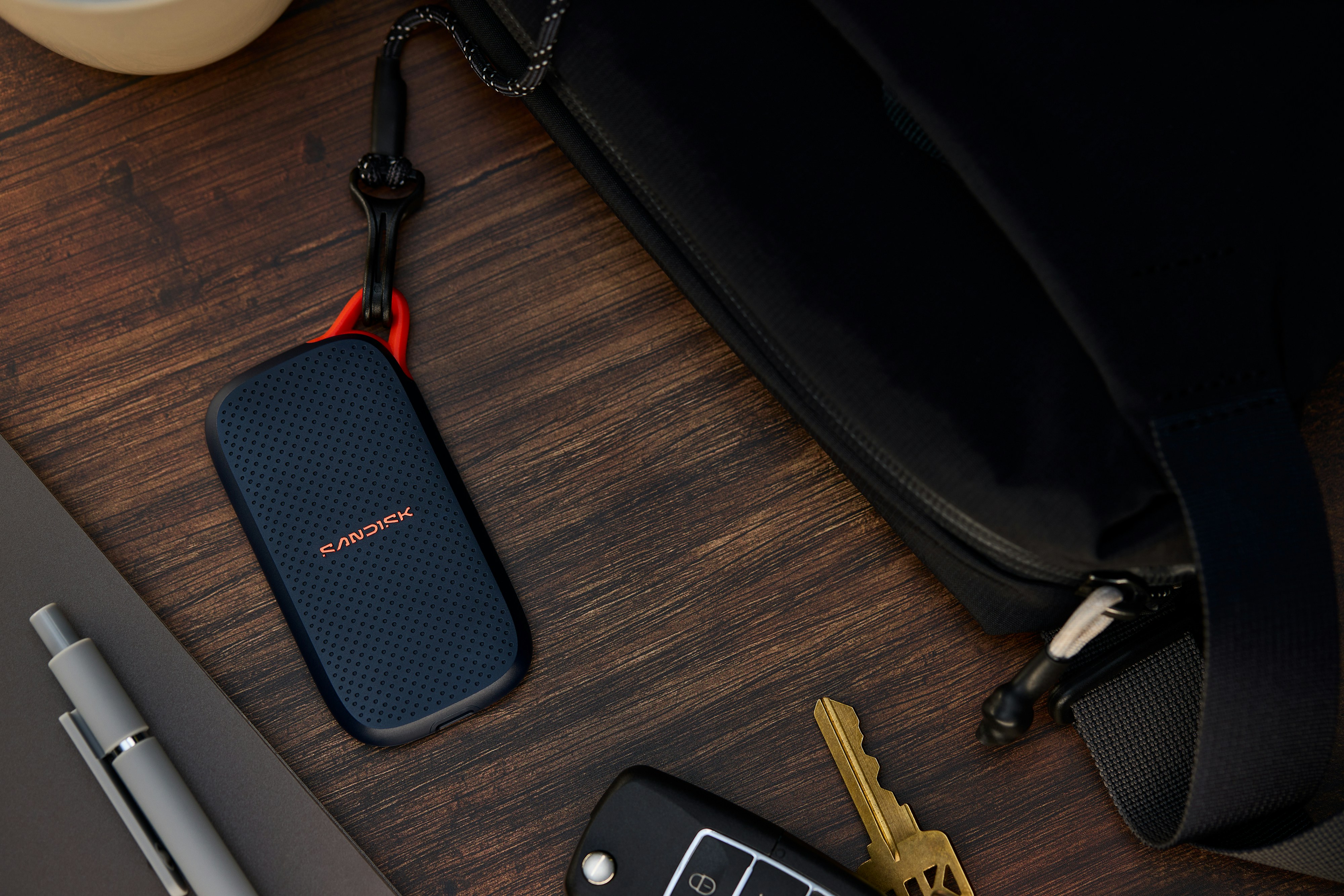Portable Ssd, Keys, And Pen Next To A Black Bag. HD mobile wallpaper