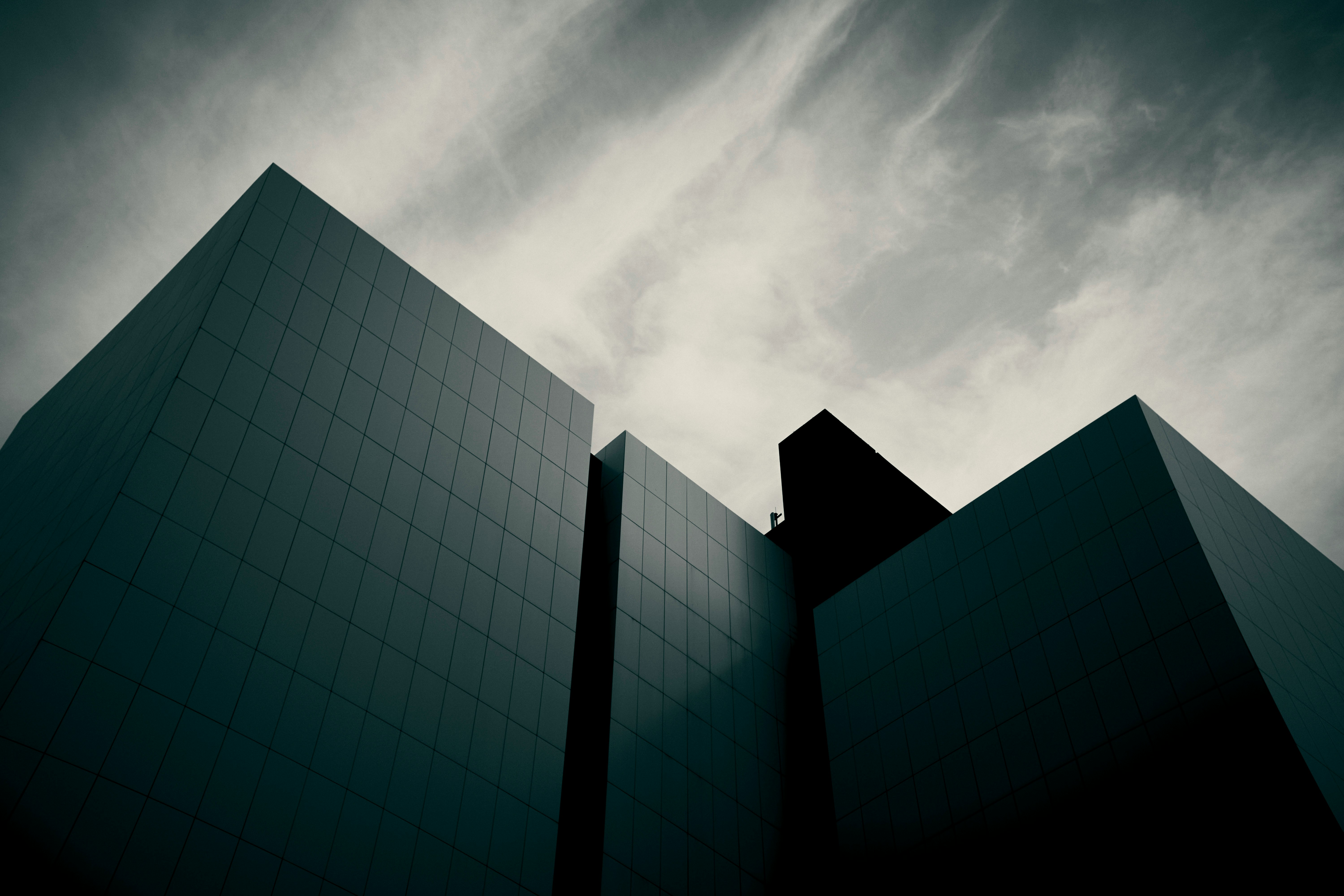 Dark, Angular Modern Buildings Against A Dramatic Cloudy Sky. HD mobile wallpaper