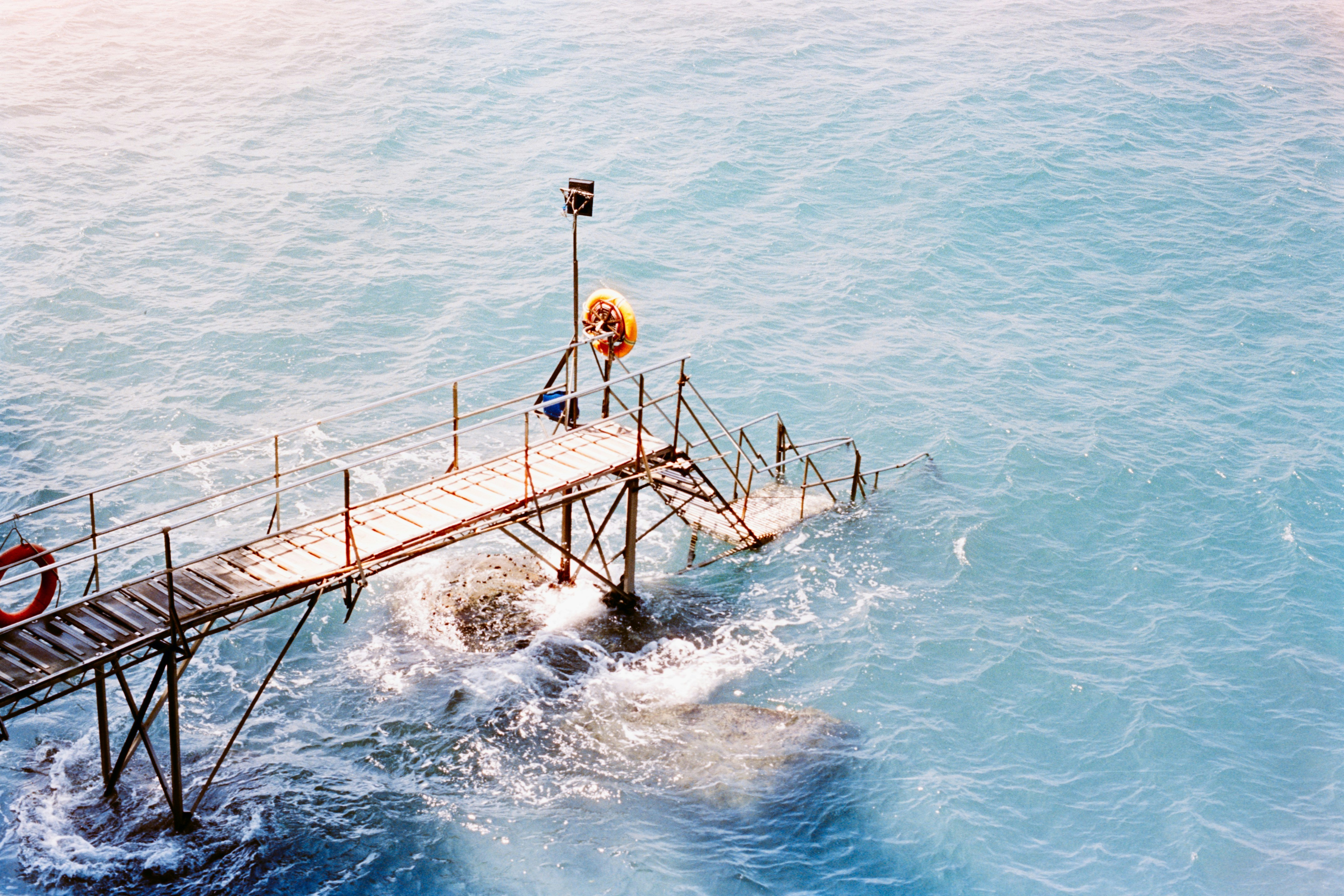 一道木质之桥延伸到碧蓝的大海中，波涛汹涌手机壁纸高清图片