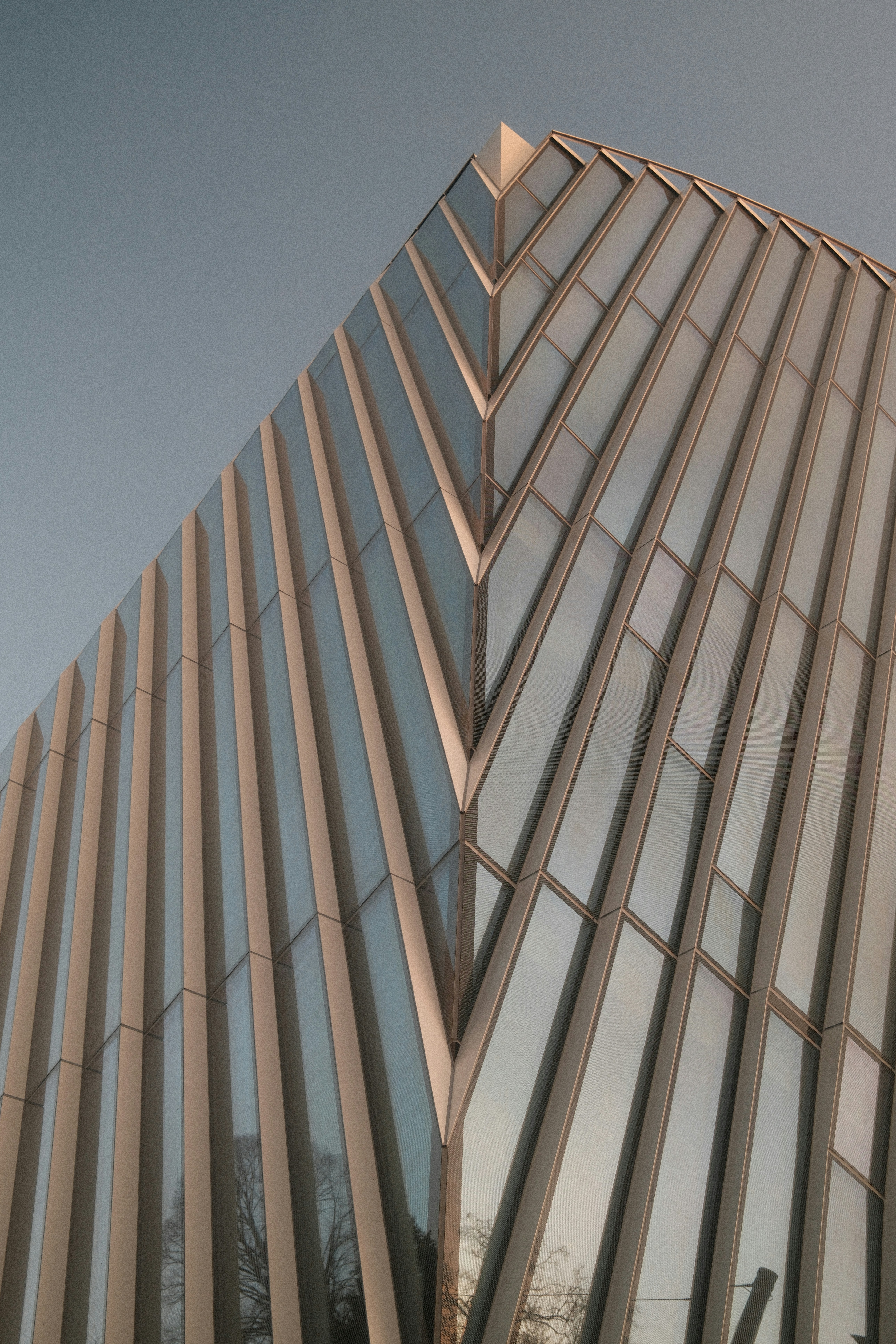 Modern Building With Reflective Glass Facade And Sharp Architectural Angles. HD mobile wallpaper