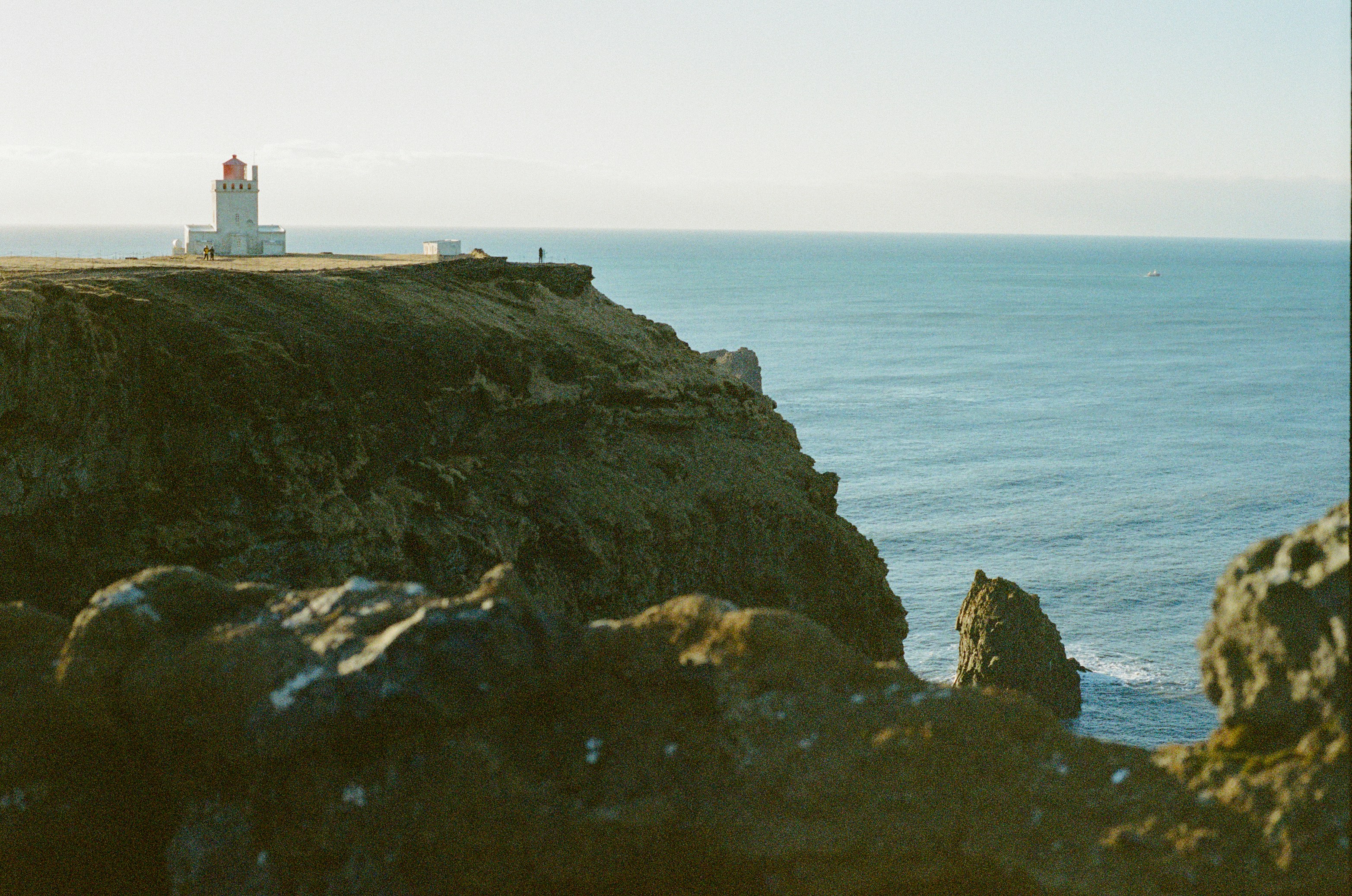 White Lighthouse On A Rugged Cliff By The Ocean. HD mobile wallpaper