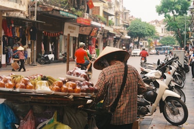 Street Vendor Selling Fruit On A Busy City Street. wallpaper preview