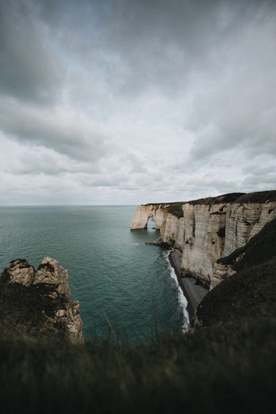 White Cliffs Meet The Ocean Under A Dramatic Cloudy Sky.