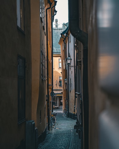 古老的斯德哥尔摩老城 Gamla Stan 的鹅卵石路衬着温暖的橙色和红色古色建筑壁纸预览