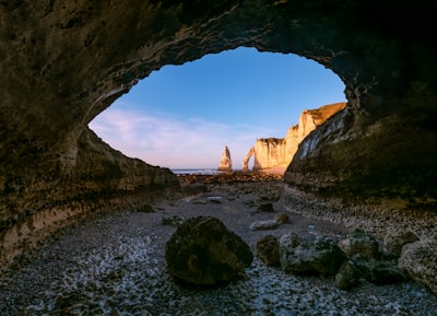 Sea Cave Entrance Framing Distant Cliffs And A Natural Arch.