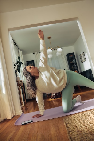 A Woman Does A Yoga Pose On A Mat. wallpaper preview