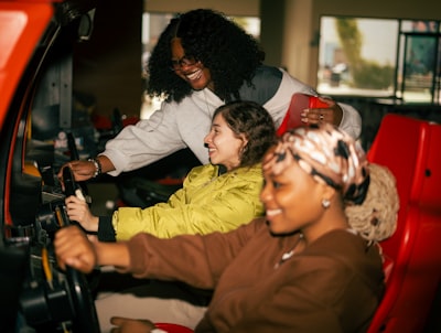 Three Friends Playing A Racing Arcade Game Together wallpaper preview