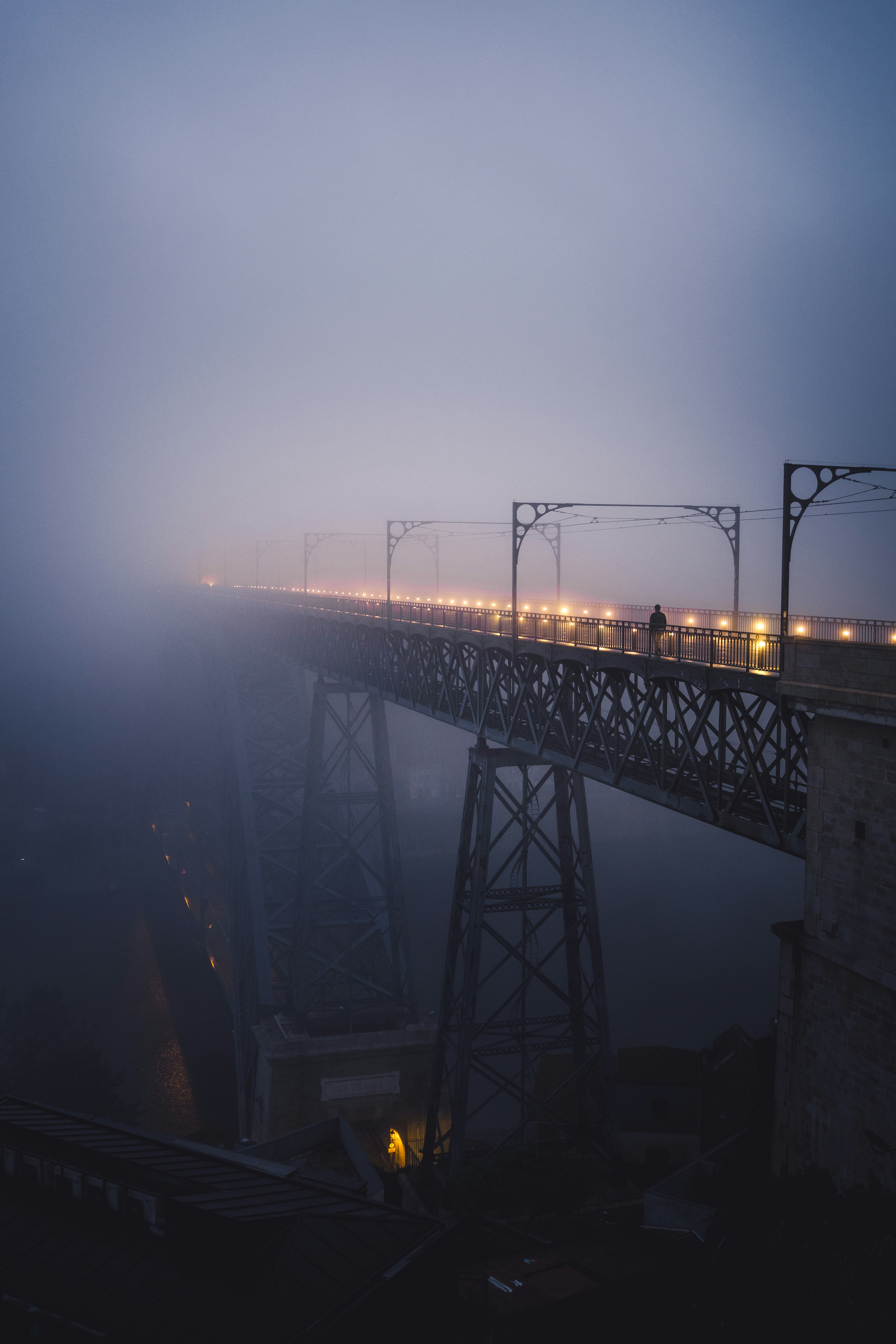 A Person Walks On A Foggy, Illuminated Bridge At Dusk. HD mobile wallpaper