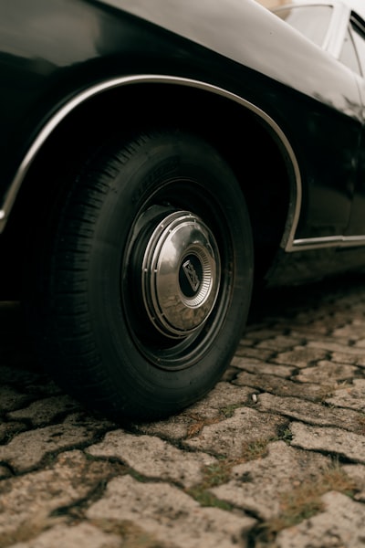 Close Up Of A Vintage Car Wheel On Cobblestone wallpaper preview