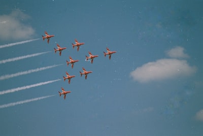 Nine Red Jet Planes Flying In A Precise Formation.