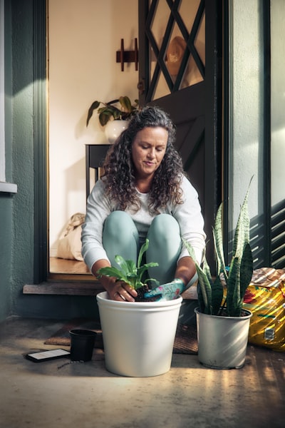 Woman Potting A Plant On A Porch wallpaper preview