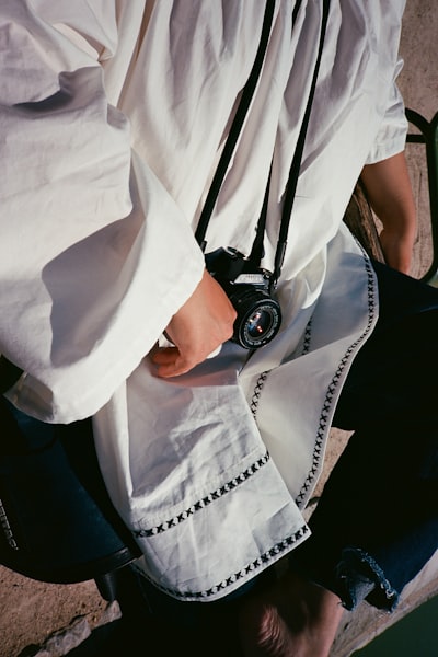 Person In White Shirt Holding A Camera. wallpaper preview