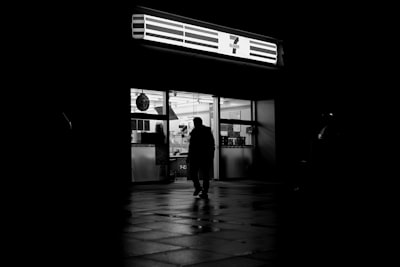 夜晚的商店中一个人走进明亮的光芒