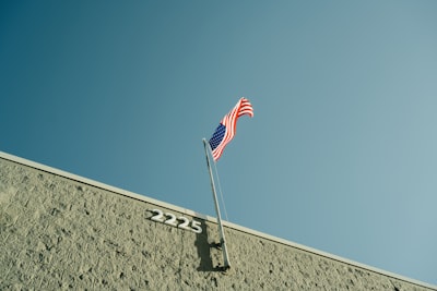 Us Flag On A Building Under A Blue Sky.