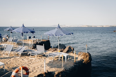 Sandy Beach With Blue Umbrellas, Lounge Chairs, And Ocean View. wallpaper preview