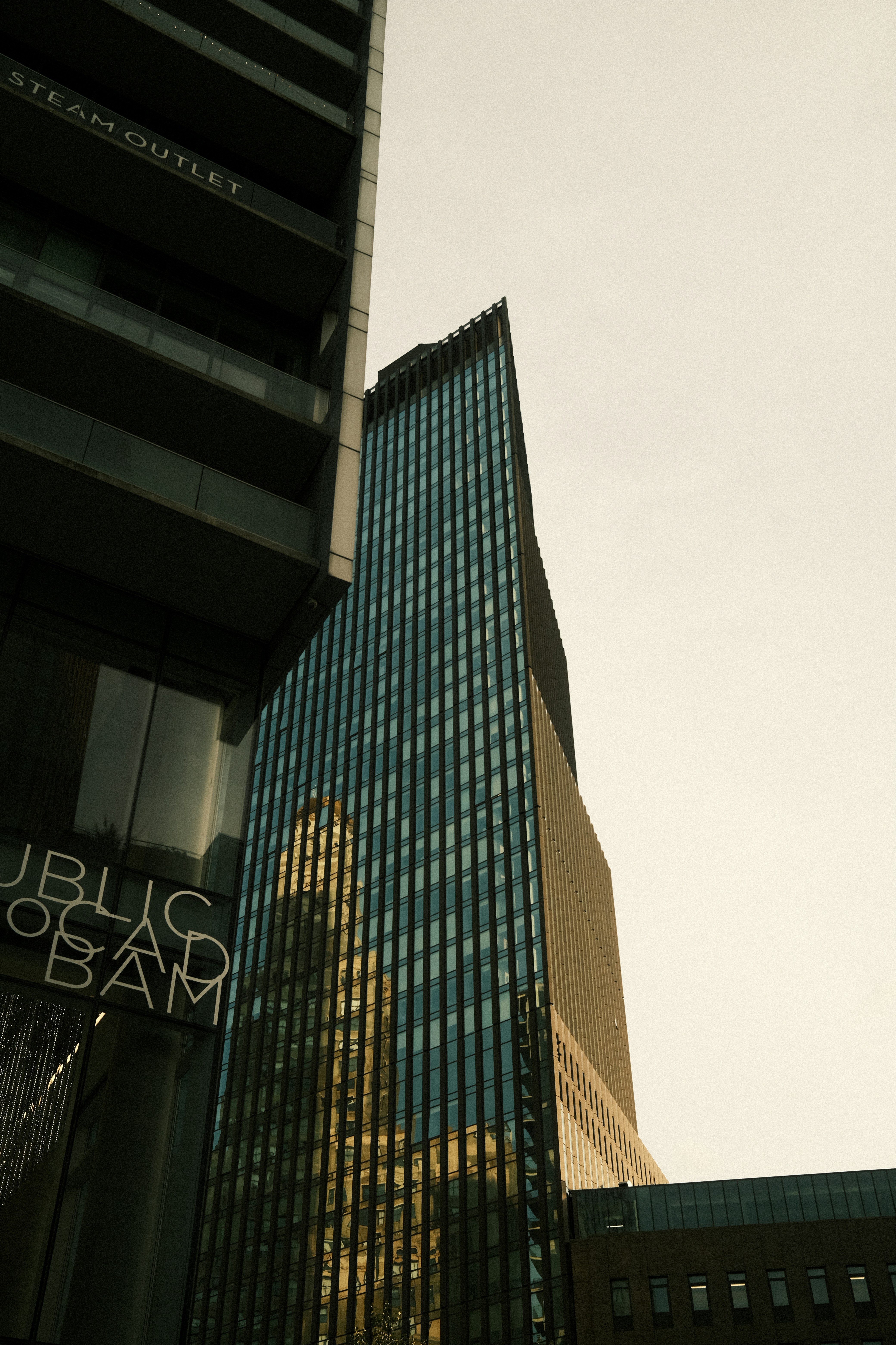 Tall Glass Skyscraper Reflects City Buildings Against A Clear Sky. HD mobile wallpaper