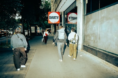 People Walk Past A Darty Store On A City Street. wallpaper preview