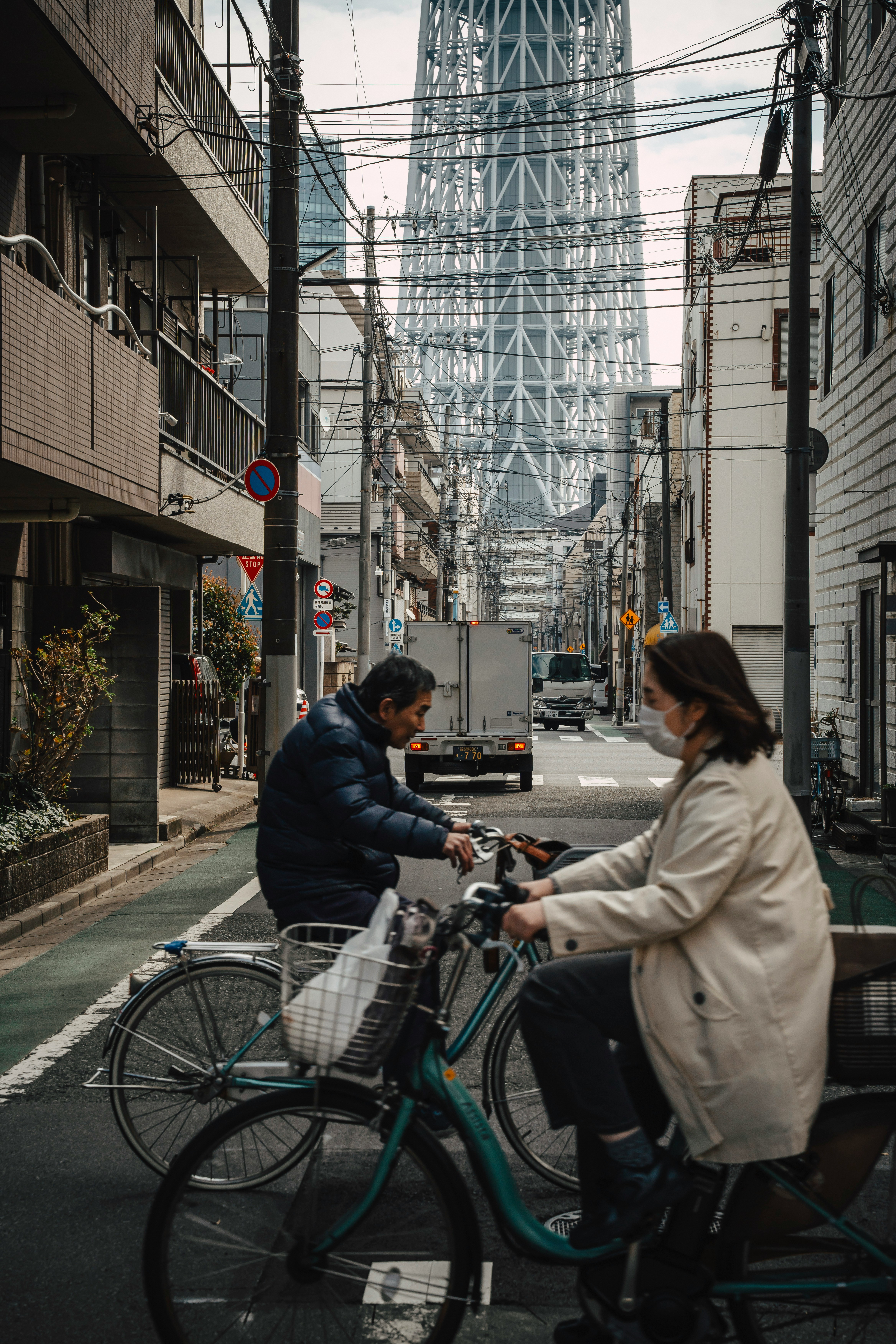 Cyclists On Tokyo Street Beneath Skytree HD mobile wallpaper