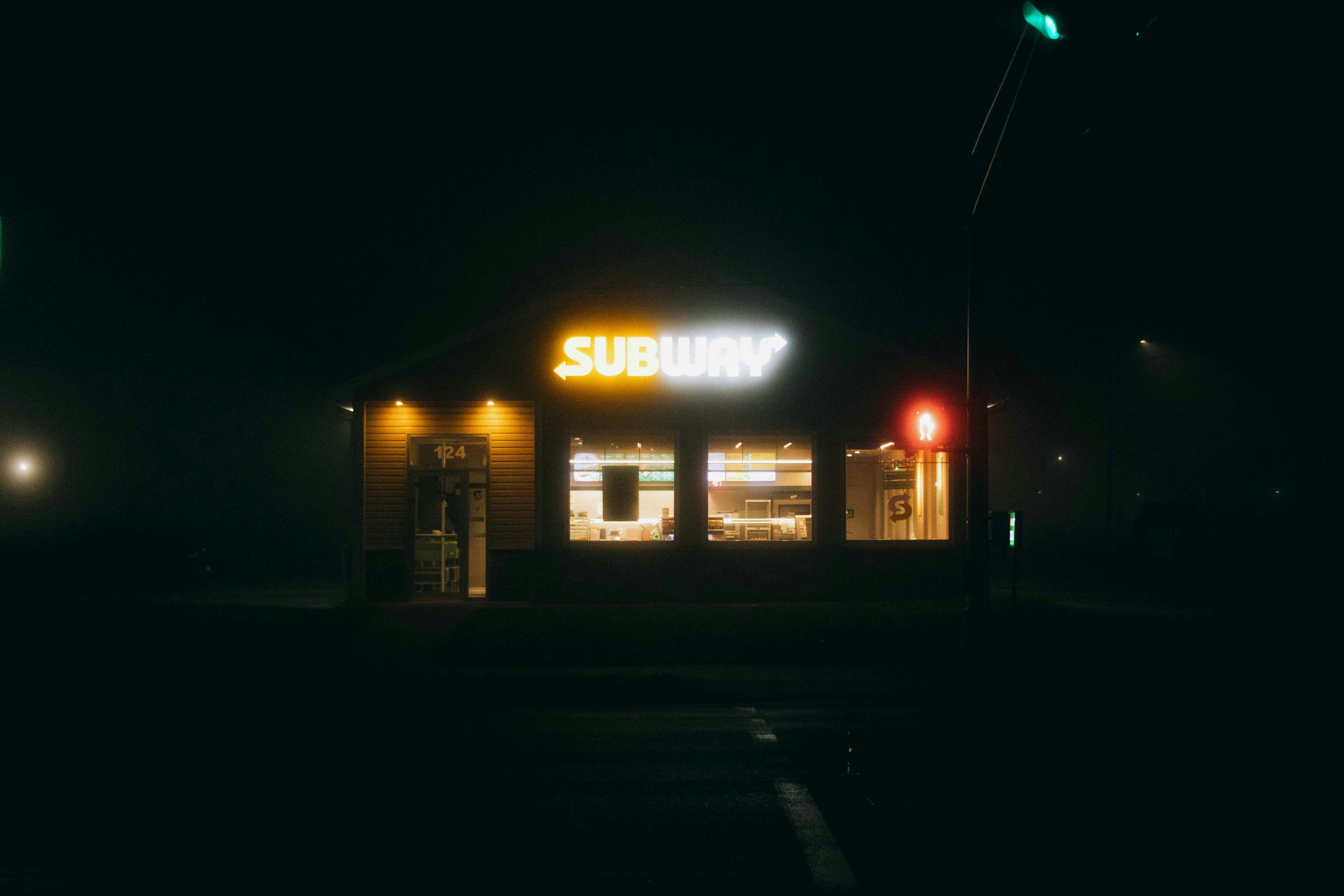 Illuminated Subway Restaurant At Night With A Red Traffic Light. HD mobile wallpaper