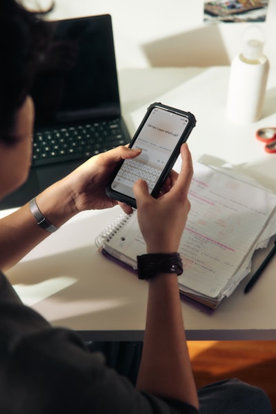 Person Using A Smartphone Over A Notebook wallpaper preview