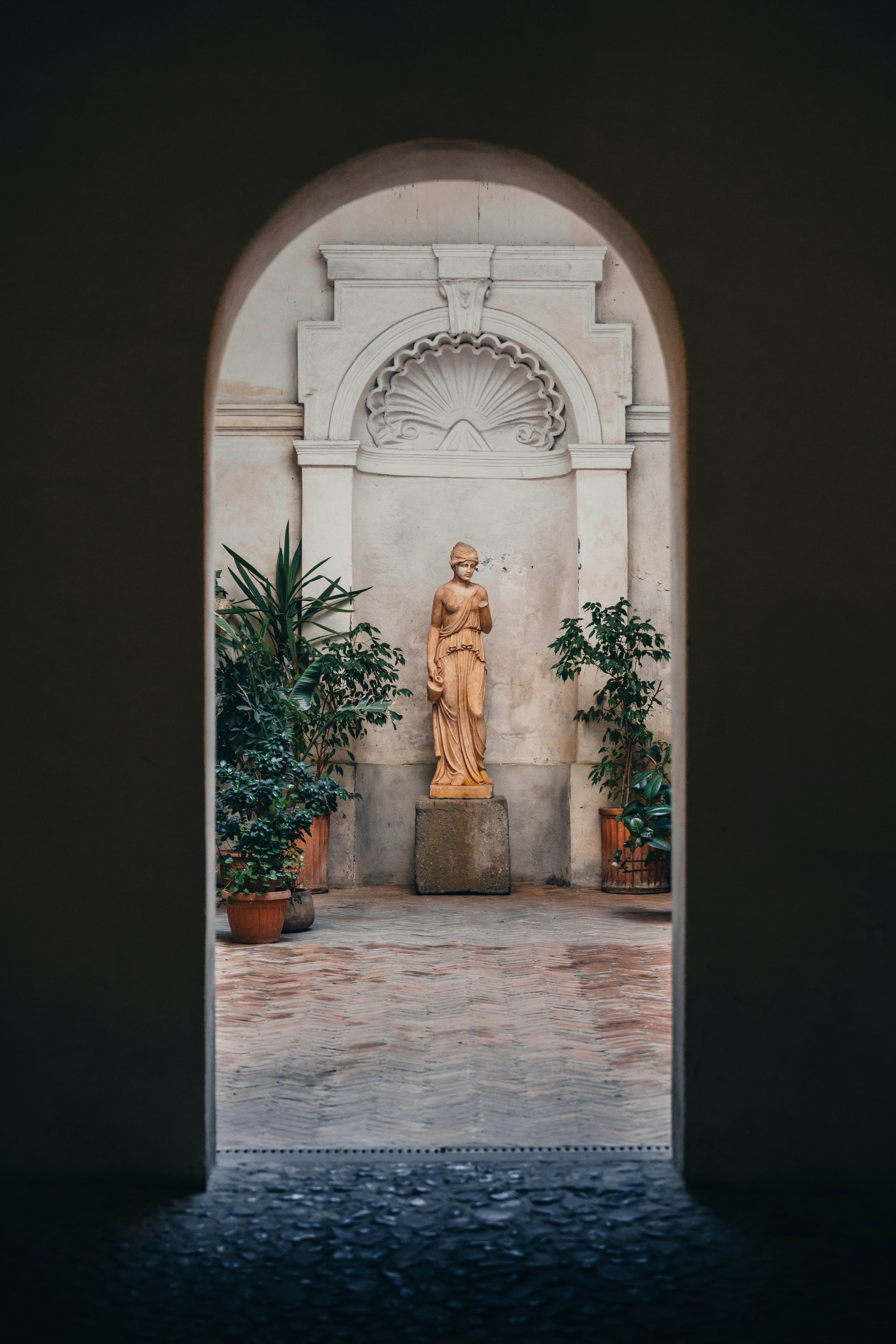 Arched Doorway Frames Classical Statue And Potted Plants In Courtyard. HD mobile wallpaper
