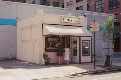 Two Customers Stop Outside A Small Neighborhood Bakery On A Sunny Afternoon In Philadelphia. wallpaper preview