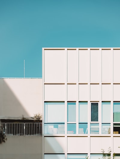 Modern White Building With Windows Under A Clear Blue Sky.