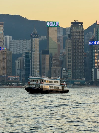 Ferry Boat Sails Across A Bay With City Skyline.