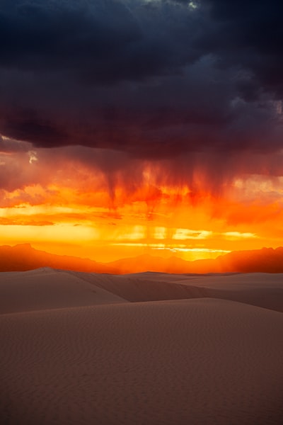 Dramatic Sunset Over Sand Dunes With Rain Falling. wallpaper preview